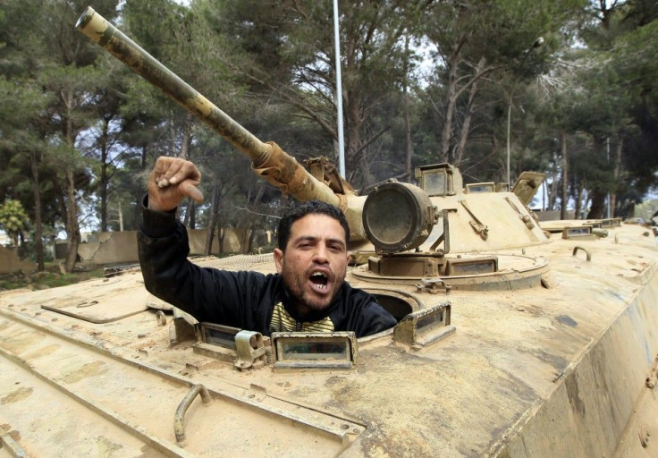 A man gestures as he sits in an army armoured vehicle in Shahat