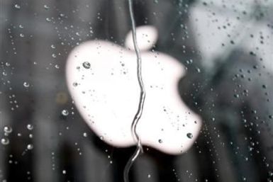 Apple Inc. logo seen through raindrops on window of Apple store in New York