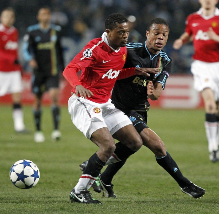 Olympique Marseille's Remy challenges Manchester United's Evra during their Champions League soccer match at the Velodrome stadium in Marseille