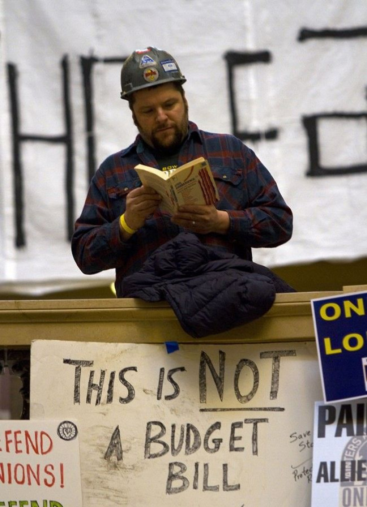 A union worker reads a book inside the state capitol during the eighth day of protests against the proposed bill by Governor Scott Walker in Madison, Wisconsin February 22, 2011.