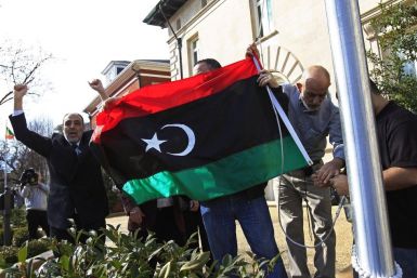 Demonstrators cheer as they raise a Kingdom of Libya flag at the residence of the Libyan ambassador in Washington