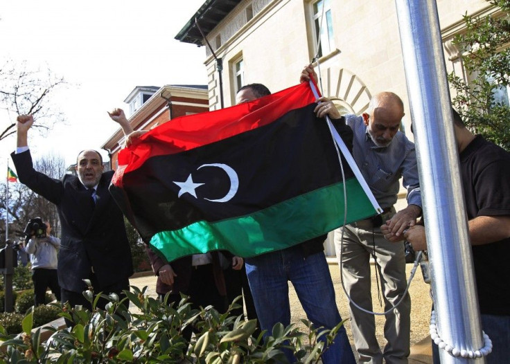 Demonstrators cheer as they raise a Kingdom of Libya flag at the residence of the Libyan ambassador in Washington