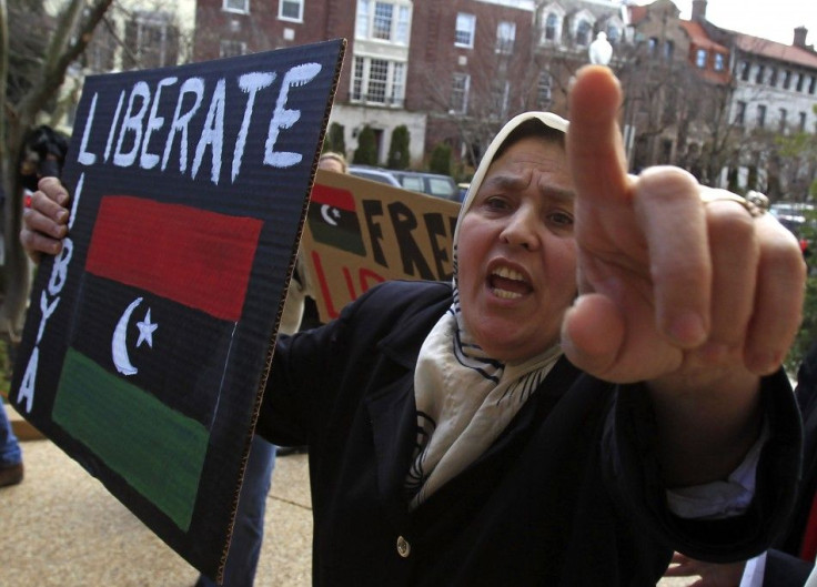 A Libyan-American woman gestures while holding a placard during a protest against Muammar Gaddafi, at the residence of the Libyan ambassador, in Washington