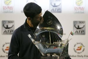 Novak Djokovic of Serbia poses with the trophy after winning his final match against Roger Federer of Switzerland at the ATP Dubai Tennis Championships.