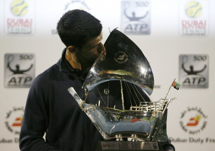 Novak Djokovic of Serbia poses with the trophy after winning his final match against Roger Federer of Switzerland at the ATP Dubai Tennis Championships.