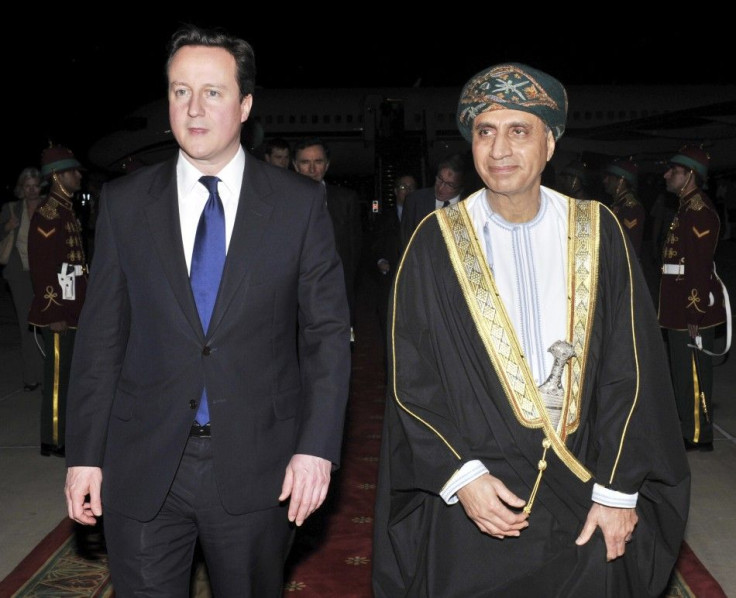 British PM Cameron walks with Omani Deputy PM for the Council of Ministers Sayyid Fahd upon his arrival in Muscat