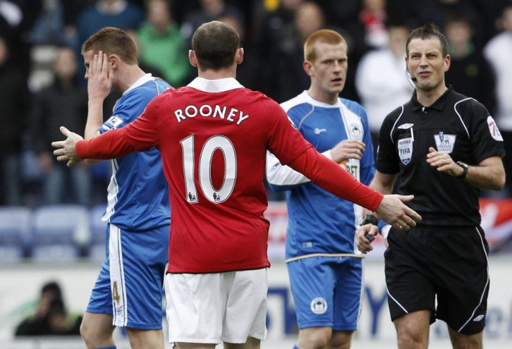 Rooney gestures towards referee Clattenburg after clashing with Wigan Athletics' McCarthy during their EPL soccer match in Wigan.