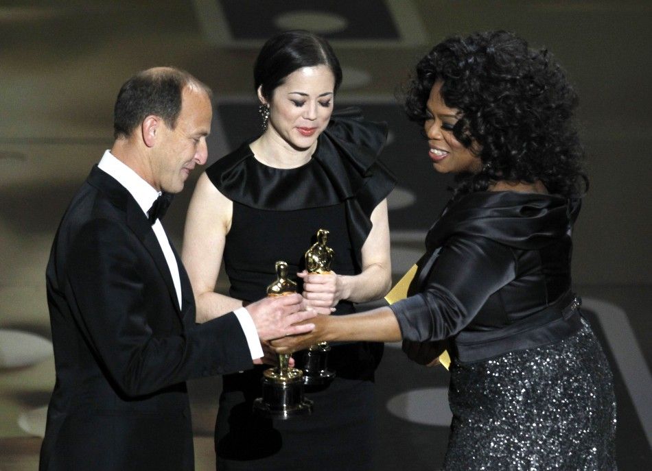 Charles Ferguson and Audrey Marrs accept the Oscar for best documentary feature for quotInside Job,quot from presenter Winfrey during the 83rd Academy Awards in Hollywood, California.