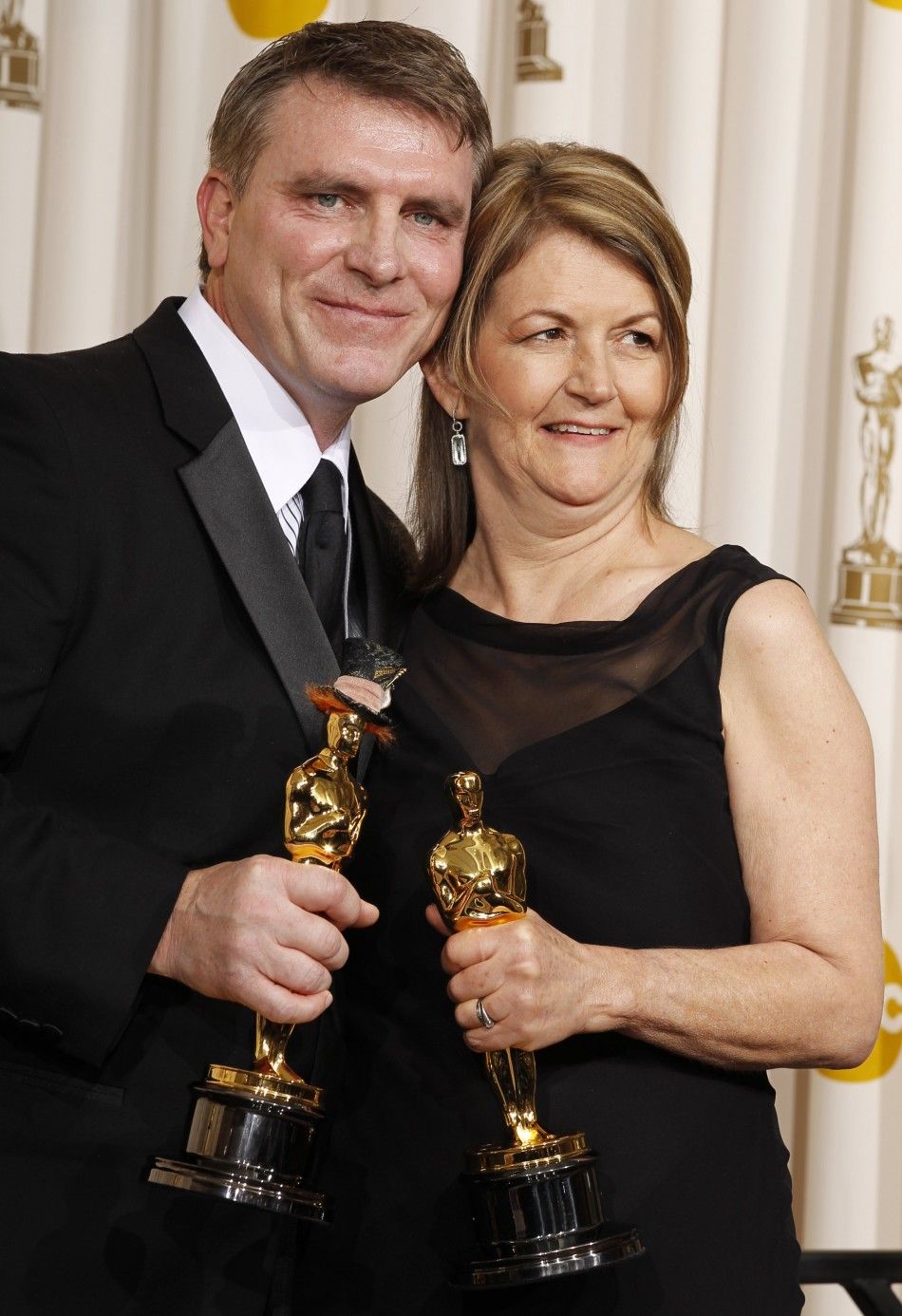 Stromberg and OHara hold their Oscars for Achievement in Art Direction for Alice in Wonderland as they pose backstage at the 83rd Academy Awards in Hollywood