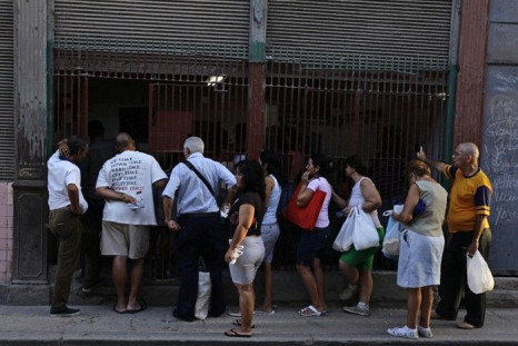 People queue at a state food outlet or 'bodega' on a street of Havana