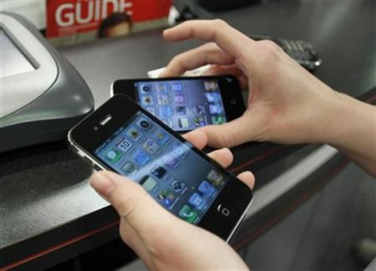 Customer holds iPhones she purchased shortly after the phone went on sale with the Verizon Wireless network in Boca Raton, Florida