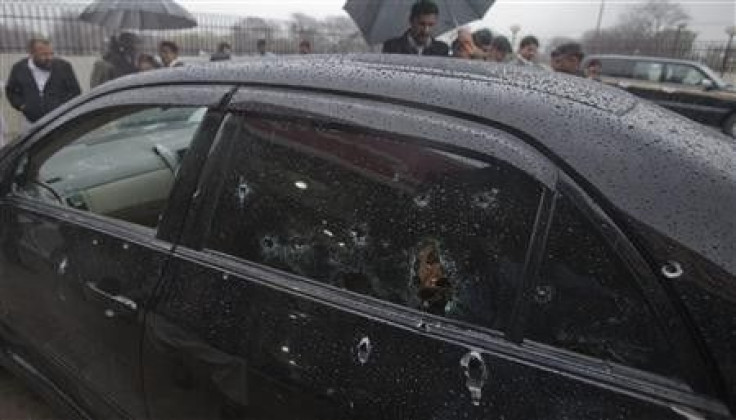 Security officials examine the bullet-riddled car of slain Pakistan's Minister for Minorities Shahbaz Bhatti 