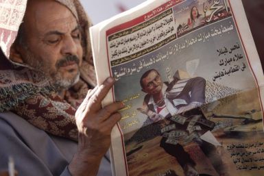 A man reads a local newspaper at Tahrir Square in Cairo