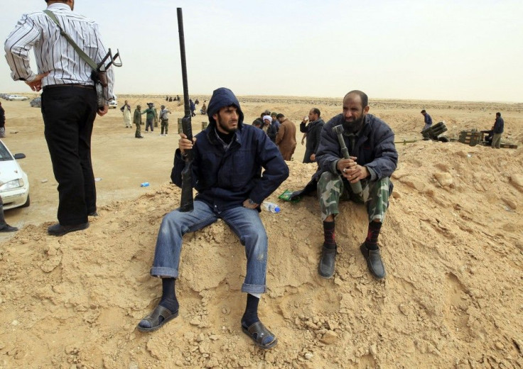 A rebel holds a gun on the outskirts of Ajdabiya, on the road leading to Brega