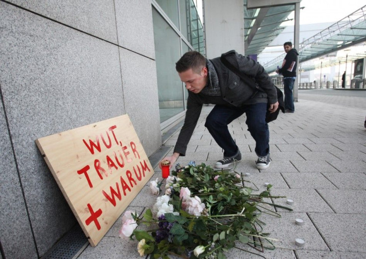 A mourner puts down a candle at the airport in Frankfurt