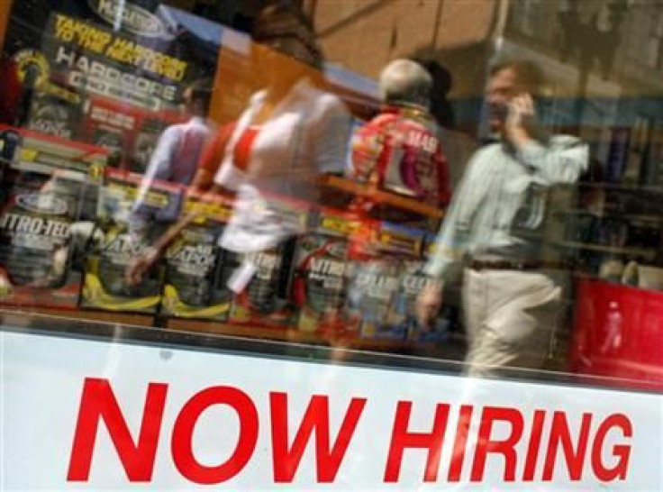 Pedestrians walk past a &quot;Now Hiring&quot; sign in the window of a GNC shop in Boston, Massachusetts 