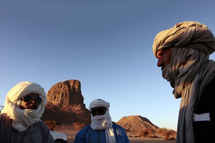 Tuareg men stand in front of the Iharen peak near southern city of Tamanrasset
