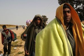 Bangladeshi evacuees walk away from the border after fleeing unrest in Libya