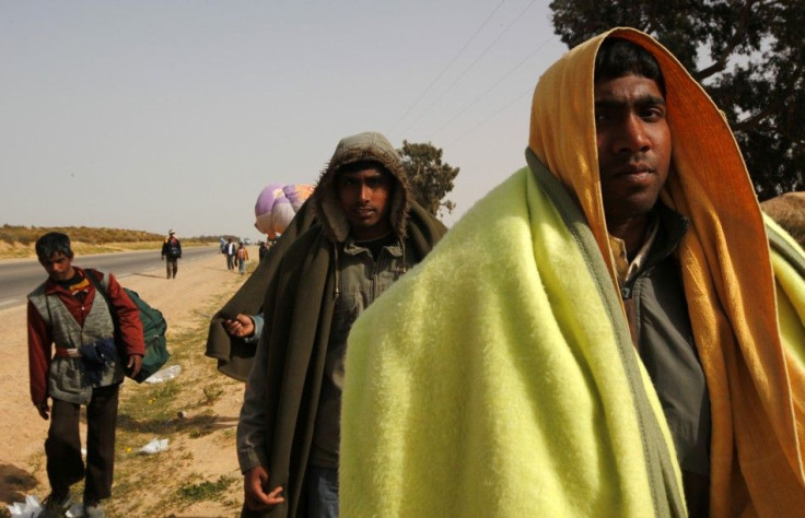 Bangladeshi evacuees walk away from the border after fleeing unrest in Libya