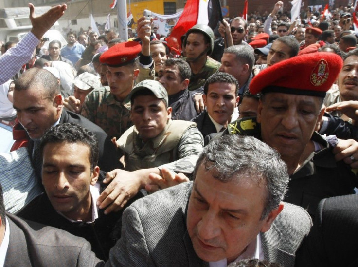 Egypt's new PM-designate Sharaf walks before delivering a speech in Cairo