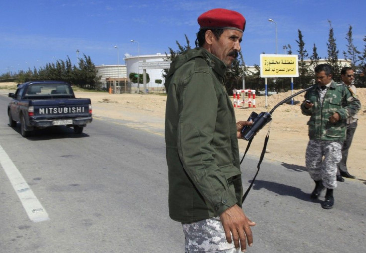 Security guards check vehicles entering the Azzawiya oil refinery in Zawiyah