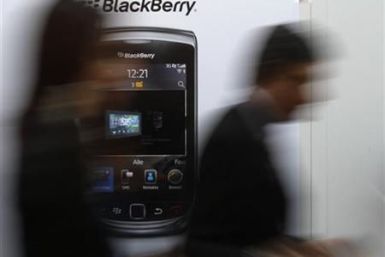 Visitors pass advertising banner showing Blackberry mobile at CeBIT computer fair in Hanover