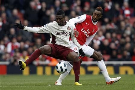 Arsenal's Johan Djourou (R) challenges Sunderland's Asamoah Gyan during their English Premier League soccer match at Emirates Stadium in London March 5, 2011.