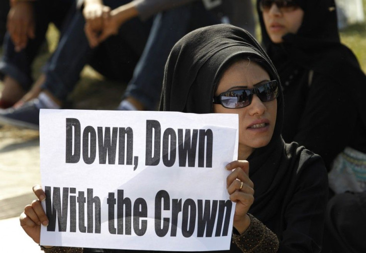 A female anti-government protester holds a banner during a protest at the Bahrain Financial Habour in Manama