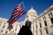 A man marches with a &quot;don't tread on me&quot; flag outside the State Capitol building in Madison, Wisconsin on February 28, 2011.