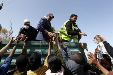 Tunisian volunteers hand out food and water to Bangladeshi migrant workers at a refugee camp near the Libyan and Tunisian border crossing of Ras Jdir