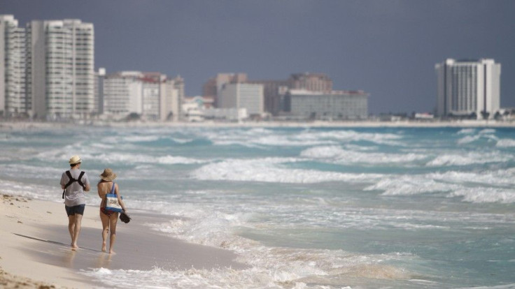 A couple walks along Marlin beach in Cancun February 1, 2011.