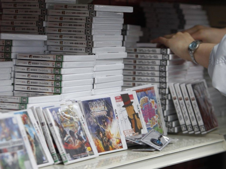 An employee reaches out for a software for Nintendo's new 3DS game console at an electronic store in Tokyo February 26, 2011.