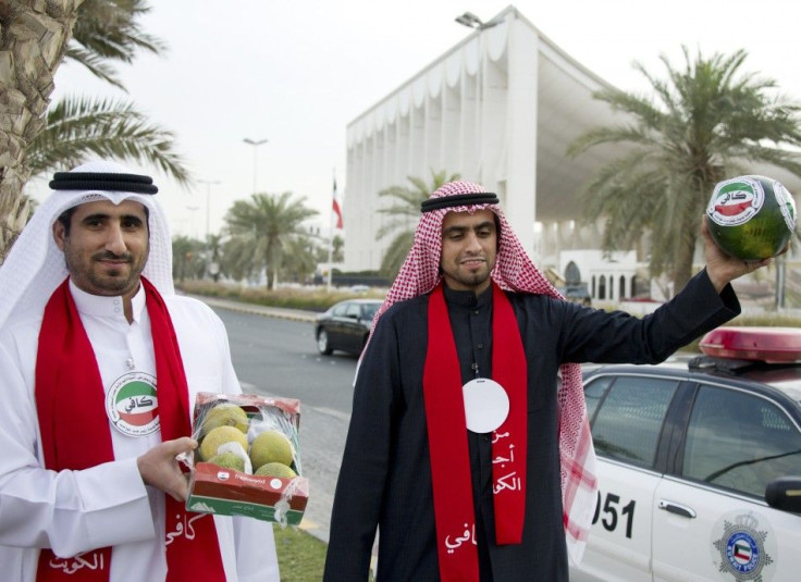 Two men from the Kuwaiti youth movement &quot;Kaafi&quot; hold watermelons as a protest in front of the Parliament building in Kuwait City