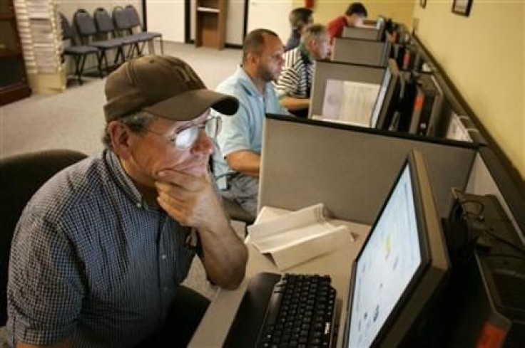 Stephen Battaglia (L) of West Palm Beach, Florida searches for jobs on a computer at Workforce Alliance in West Palm Beach