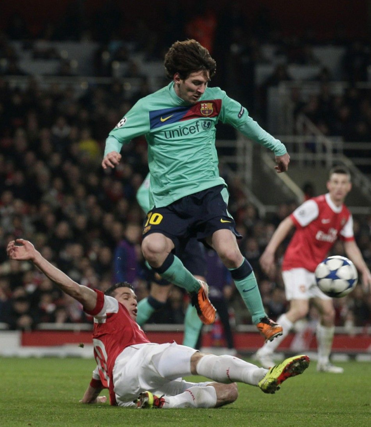 Arsenal's van Persie fights for the ball against Barcelona's Messi during their Champions League soccer match in London.