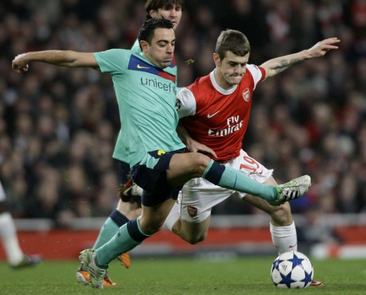 Xavi and Wilshere battle for the ball in the first leg of the tie.