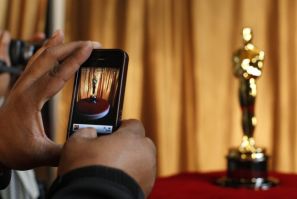 A man photographs an Oscar statuette using his phone at the &quot;Meet the Oscars&quot; exhibit at Grand Central Station in New York February 23, 2011