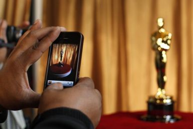 A man photographs an Oscar statuette using his phone at the &quot;Meet the Oscars&quot; exhibit at Grand Central Station in New York February 23, 2011