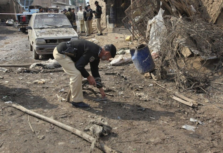 A policeman picks up debris at the site of a blast at a checkpost on the outskirts of Peshawar.