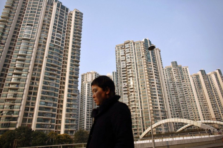 A woman walks in front of a residential site in Shanghai March 2, 2011. 
