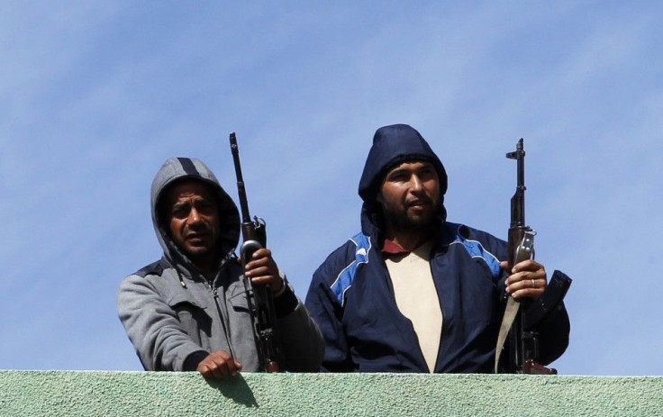 Gunmen opposed to leader Muammar Gaddafi stand guard on a rooftop in the centre of the city of Zawiyah 
