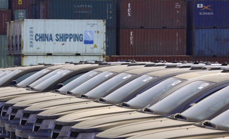 Containers can be seen stacked behind imported Buick cars, covered in dust, made by American car maker General Motors, in this picture taken March 2, 2011, at the Binhai docks area in the Chinese coastal city of Tianjin.