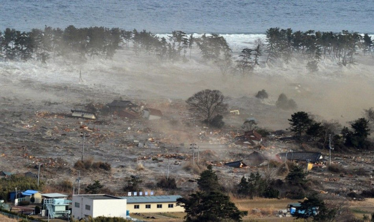 Houses are swept by a tsunami in Natori City in northeastern Japan