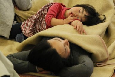 Passengers sleep at a lobby as they wait for their transportation at Haneda Airport in Tokyo