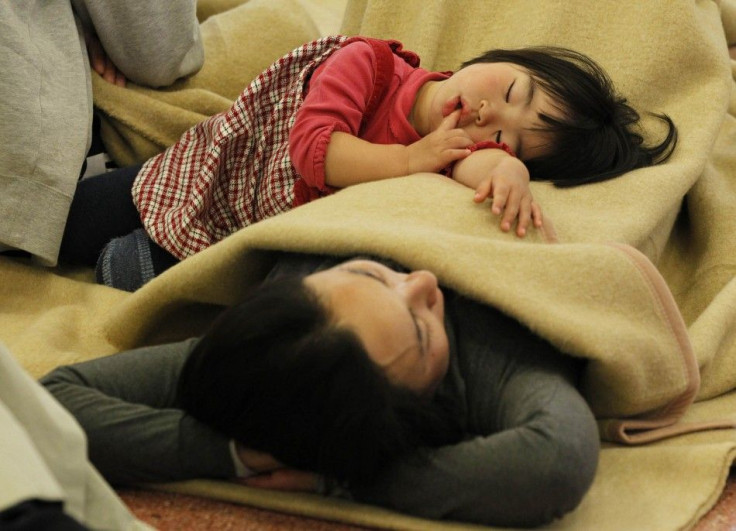 Passengers sleep at a lobby as they wait for their transportation at Haneda Airport in Tokyo