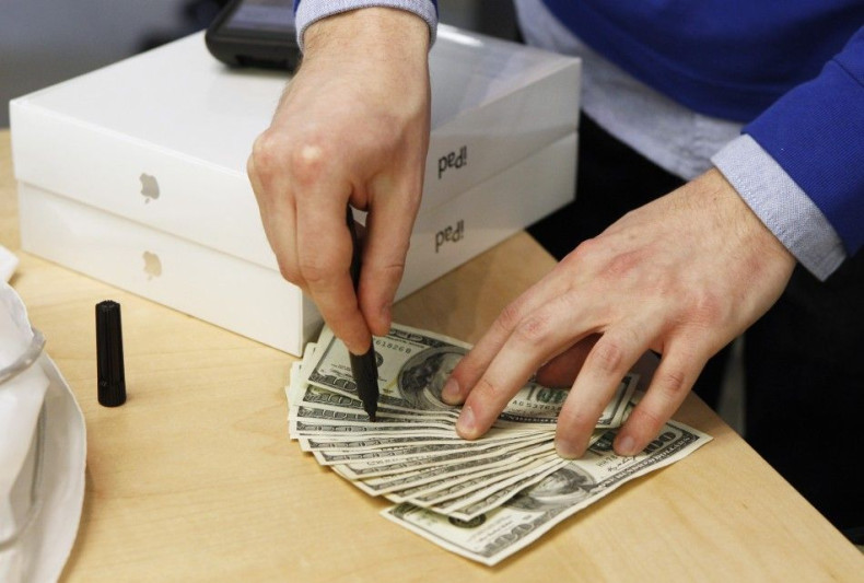 An Apple store employee checks cash for counterfeit bills after a customer purchased a pair of Apple iPad 2 tablets in New York