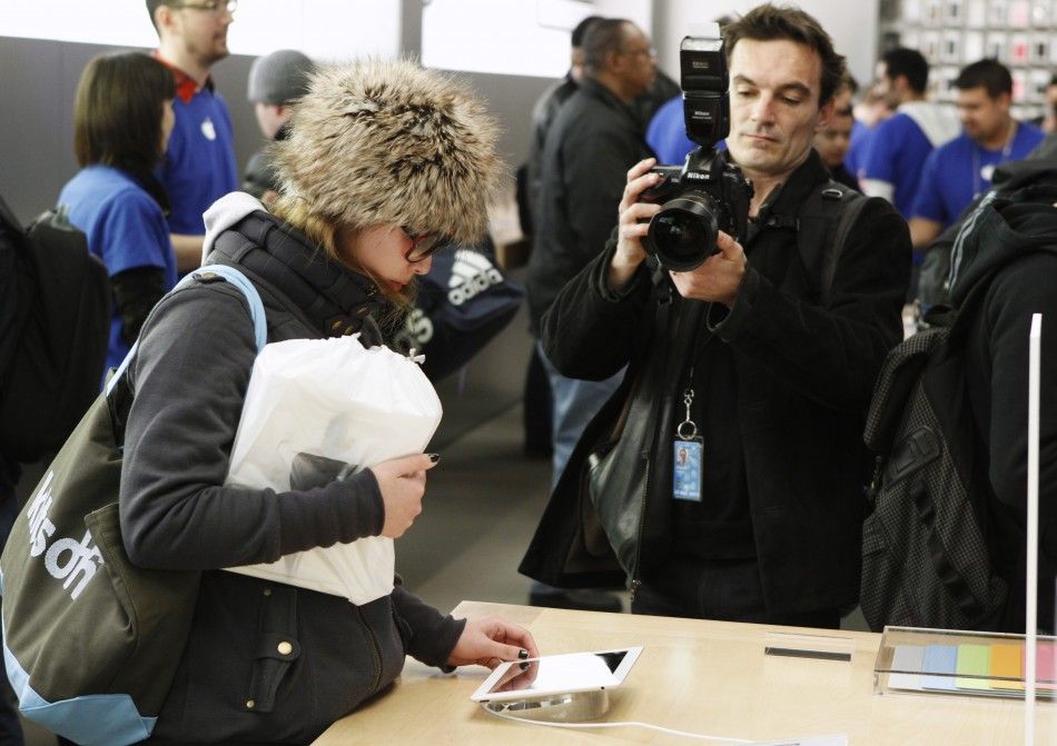 A woman inspects one of Apples iPad 2 tablets at the companys flagship 5th Ave store in New York