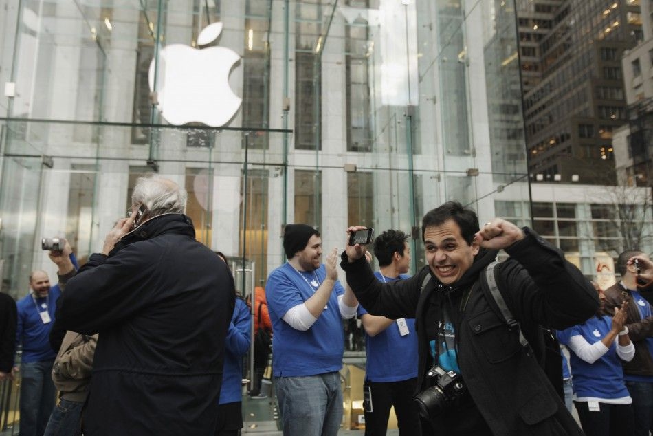 Customers walk past Apple employees to purchase iPad 2 tablets at Apples flagship 5th Ave store in New York
