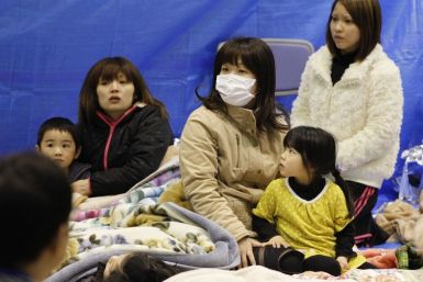 Evacuees sit through an earthquake at a temporary shelter at a stadium in Koriyama