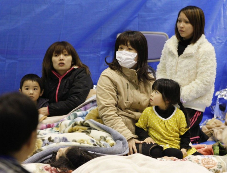 Evacuees sit through an earthquake at a temporary shelter at a stadium in Koriyama